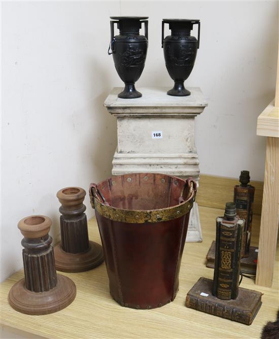 A pair of book ends, leather bucket, two large plinths/stands and a pair of candlesticks